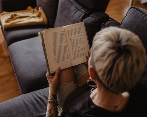 A person relaxing reading a book at home