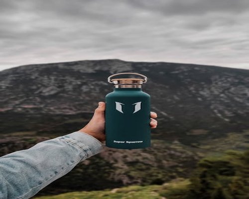 Holding a reusable water bottle outdoors